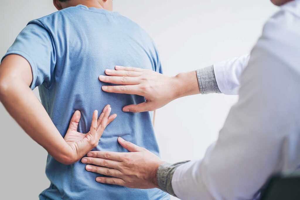 A practitioner performing a gentle neck adjustment for an adult patient in a well-lit clinic room.