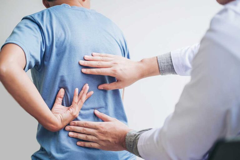 A practitioner performing a gentle neck adjustment for an adult patient in a well-lit clinic room.